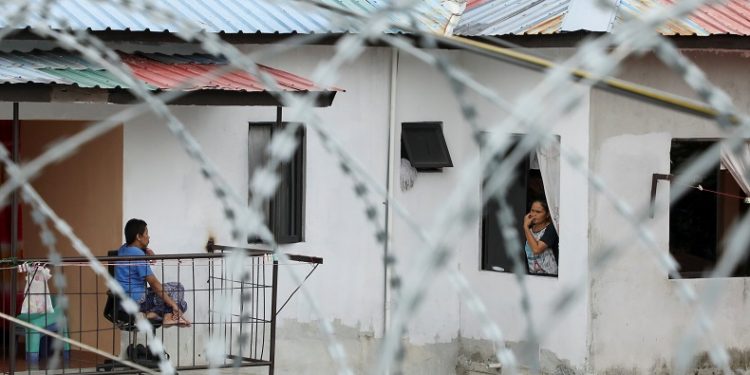 Residents talk to each other in an area under enhanced lockdown, amid the coronavirus disease (COVID-19) outbreak, in Kuala Lumpur, Malaysia June 29, 2021. REUTERS/Lim Huey Teng