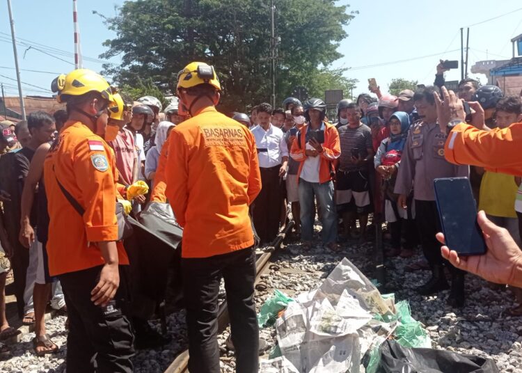 Korban tewas tertabrak kereta api saat dievakuasi tim basarnas Kota Padang, Senin (18/7/2022). (Fajar/Sumbarkita.id)