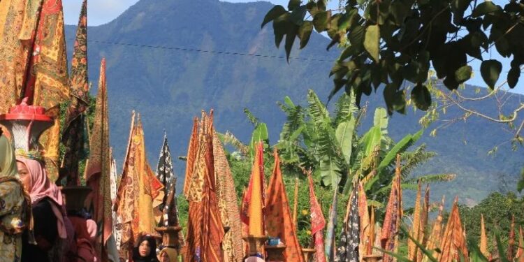 Arak-arakan 1.000 kain panjang dengan latar belakang Gunung Marapi (Foto: @/talagokamba_festival)