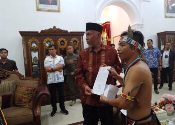 Ketua AMB Yosafat Saumanuk menyerahkan surat pernyataan sikap kepada Gubernur Sumbar, Kamis (25/8/2022) [SumbarKita/Rian Afdol]