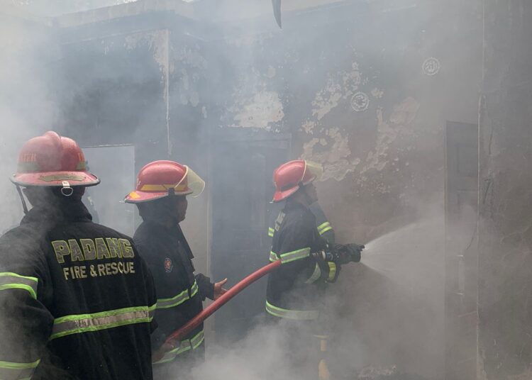 Personel Damkar Padang berusaha menjinakan api yang membakar satu petak rumah di koto tangah, Minggu (4/9/2022).