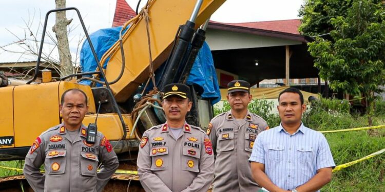 Polisi bersama satu unit alat berat yang digunakan para terduga penambang emas ilegal di Solok Selatan (ist)