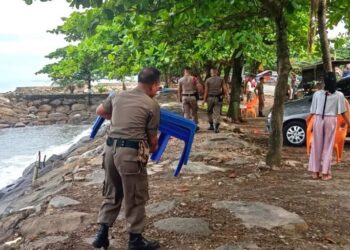 Petugas memindahkan meja PKL dari bibir Pantai Padang di Jalan Samudra, Rabu (12/10/2022)