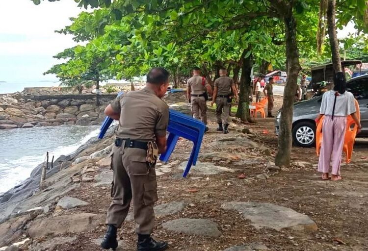 Petugas memindahkan meja PKL dari bibir Pantai Padang di Jalan Samudra, Rabu (12/10/2022)