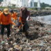 Petugas membersihkan sampah di Pantai Padang.