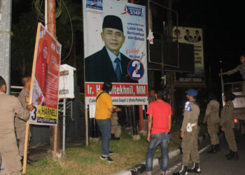 Satpol PP Padang membongkar alat peraga kampanye caleg, Senin (25/12).