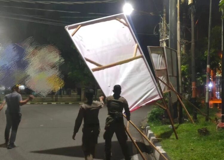 Satpol PP Kota Padang mencopot spanduk dan reklame yang tidak memiliki izin (foto: Humas Satpol PP Kota Padang)