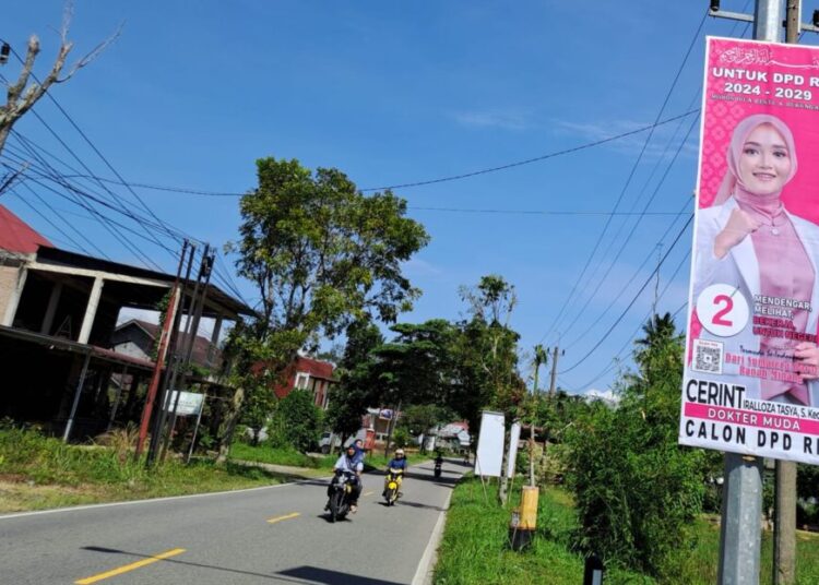 Alat peraga kampanye salah satu Calon Anggota DPD terpasang di tiang listrik pinggir jalan Kabupaten Pasaman.