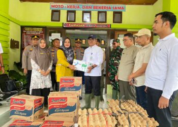 Pemimpin Cabang Bank Nagari Painan Helfiyanrika saat menyerahkan bantuan bagi korban banjir di IV Jurai.