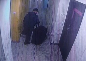 Pelaku menyeret koper berisi mayat wanita (foto: rekaman CCTV)