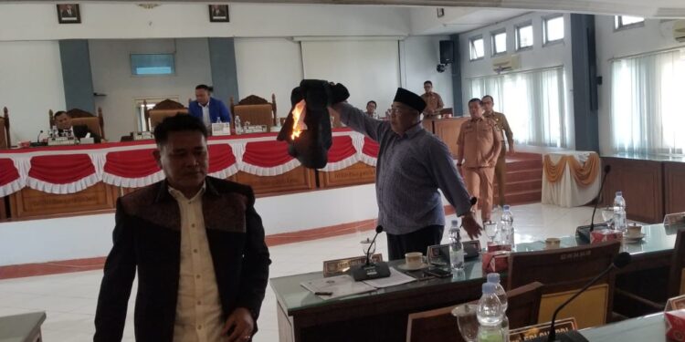 Ketua Fraksi Partai Gerindra Khairul Apit membakar jas miliknya di Sidang Paripurna DPRD Limapuluh Kota, Selasa (25/6).