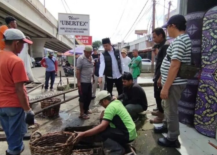 Wali Kota Bukittinggi Erman Safar saat gotong royong membersihkan drainase Pasar Aur Kuning, Minggu (16/6/2024).