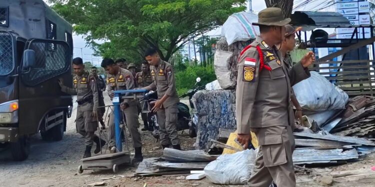 Petugas menindak gudang barang bekas di Jalan Bypass Kota Padang.