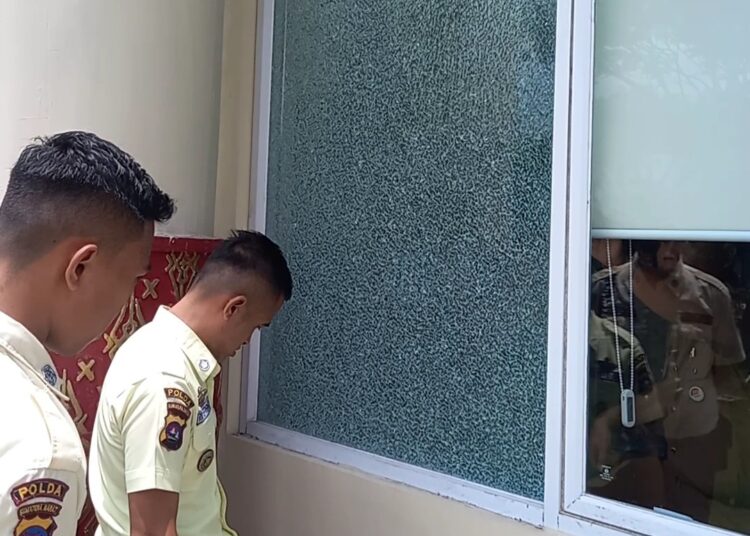 Petugas keamanan Kantor DPRD Kota Padang memantau lokasi kaca retak (Foto: Sumbarkita.id/ Habil Ramanda)