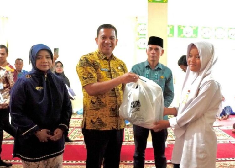 Foto Pj Wali Kota Padang Panjang menyerahkan bantuan perlengkapan sekolah ke pelajar (foto: Diskominfo Padang Panjang)