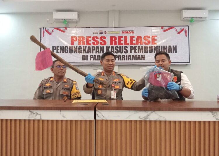 Kapolres Padang Pariaman AKBP Ahmad Faisol Amir memperlihat cangkul yang digunakan tersangka Indra Septiarman, Senin (23/9).