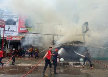 Petugas Damkar berjibaku memadamkan api yang membakar warung Ayam Goreng di Kota Payakumbuh, Senin (28/10).