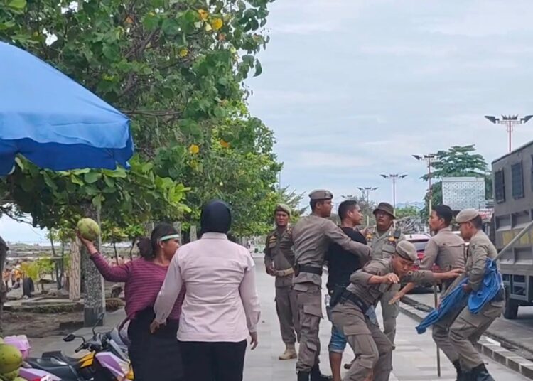 Seorang PKL di Pantai Padang melempari petugas dengan kelapa muda saat hendak ditertibkan