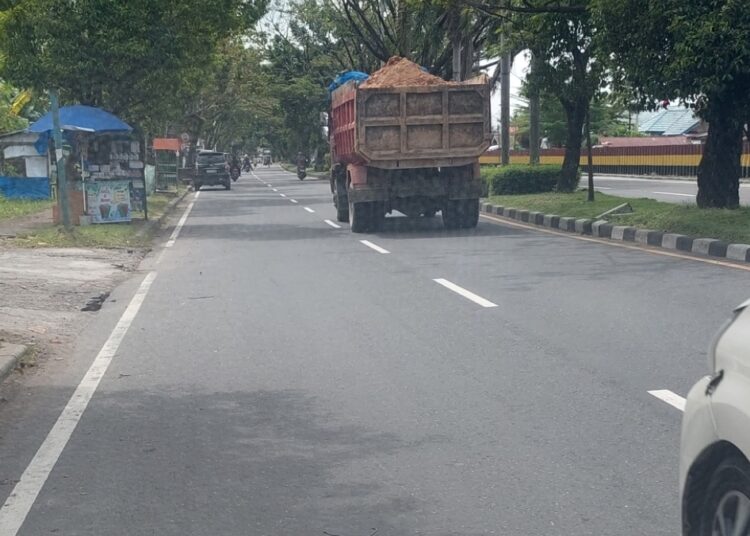 Penampakan truk pengangkut pasir tanpa terpal di jalan di Kota Padang.