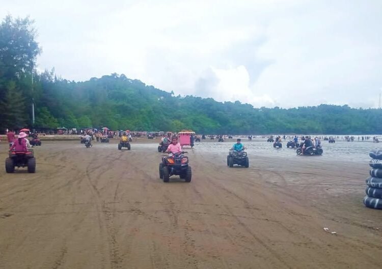 Pengunjung menikmati libur Lebaran di Pantai Air Manis Padang. Foto: Diskominfo Padang