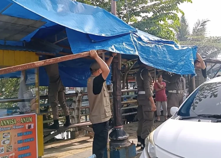 Petugas menertibkan lapak PKL di kawasan Batang Arau, Kota Padang. (foto: Instagram/Satpol PP Padang).