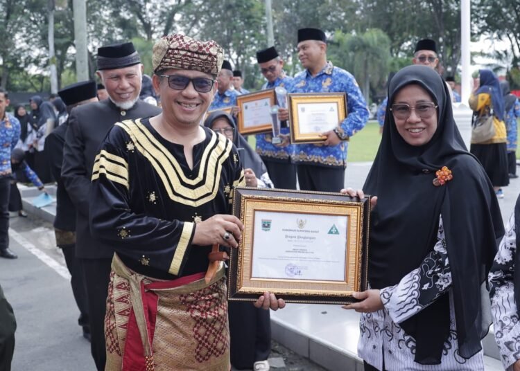 Wakil Ketua DPRD Sumbar, Evi Yandri Rajo Budiman, saat menghadiri Upacara Peringatan Hardiknas di halaman Kantor Gubernur Sumbar, Jumat (2/5). (Foto: Humas DPRD Sumbar).