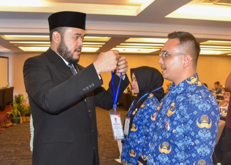 Wali Kota Padang, Fadly Amran, mengalungkan kokarde peserta Bimtek Keprotokolan dan MC bagi ASN di lingkungan Pemko Padang di Hotel Axana pada Selasa (20/5). Foto: Pemko Padang