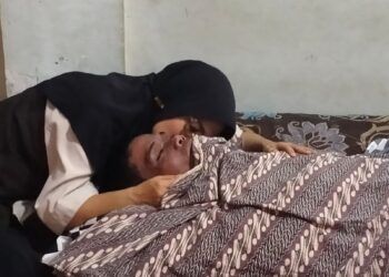 Mariza memeluk suaminya yang meninggal dunia akibat gantung diri di dalam rumah mereka di Jalan S. Parman Nomor 99, Jorong Jati, Nagari Baringin, Kecamatan Lima Kaum, pada Kamis (16/7/2026) sekitar pukul 12.30 WIB. Foto: Polsek Lima Kaum
