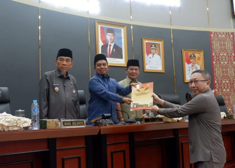 Juru bicara Fraksi PDIP-PPP, Christian Rudy Kurniawan Sutiono, menyampaikan dokumen pandangan fraksinya kepada Ketua DPRD Padang dalam rapat paripurna di Gedung DPRD Padang pada Senin (17/7/2026). Mengki Kurniawan/Sumbarkita