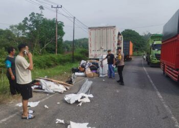 Sejumlah paket berserakan di jalan setelah sebuah dump truck dan truk boks ekspedisi J&T bersenggolan di Jalan Lintas Sumatera di Jorong Sungai Baye, Nagari Sungai Rumbai, Kecamatan Sungai Rumbai, Dharmasraya, Sumatera Barat (Sumbar), pada Sabtu (18/7/2026) pukul 08.00 WIB. Foto: Polres Dharmasraya