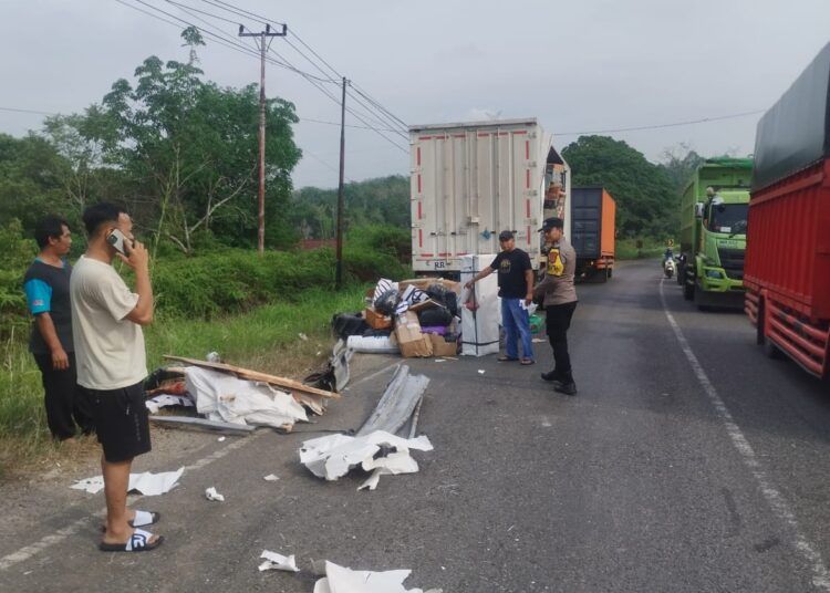 Sejumlah paket berserakan di jalan setelah sebuah dump truck dan truk boks ekspedisi J&T bersenggolan di Jalan Lintas Sumatera di Jorong Sungai Baye, Nagari Sungai Rumbai, Kecamatan Sungai Rumbai, Dharmasraya, Sumatera Barat (Sumbar), pada Sabtu (18/7/2026) pukul 08.00 WIB. Foto: Polres Dharmasraya