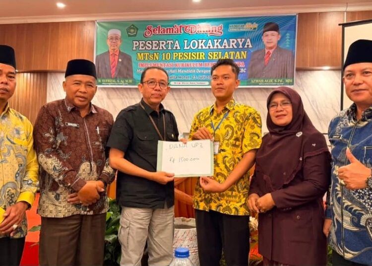 Kepala Kantor Kemenag Pesisir Selatan, Yufrizal, memberikan bantuan uang Rp1,5 juta secara simbolis kepada Hamdani di sela-sela lokakarya di Gisella Hotel, Pasar Baru, Kecamatan Bayang, pada 23 Juli 2026. Foto: MTsN 10 Pesisir Selatan