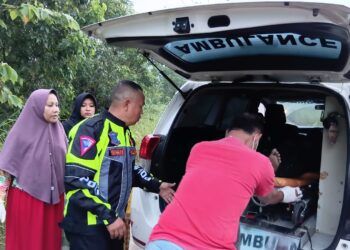 Petugas mengevakuasi jenazah korban kecelakaan sepeda motor yang menabrak pembatas jalan di Jalur Dua Simpang SMKN 1 Sungai Rumbai, Kabupaten Dharmasraya. Foto: Polres Dharmasraya