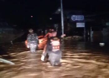 Tim gabungan mengevakuasi warga yang terjebak banjir di salah satu kawasan terdampak di Kota Padang, Senin (3/8/2026)