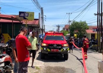 Petugas Dinas Pemadam Kebakaran Kota Padang berupaya memadamkan api yang melalap sebuah minimarket di Jalan Belibis, Kelurahan Air Tawar Barat, Kecamatan Padang Utara, Rabu (5/8/2026).