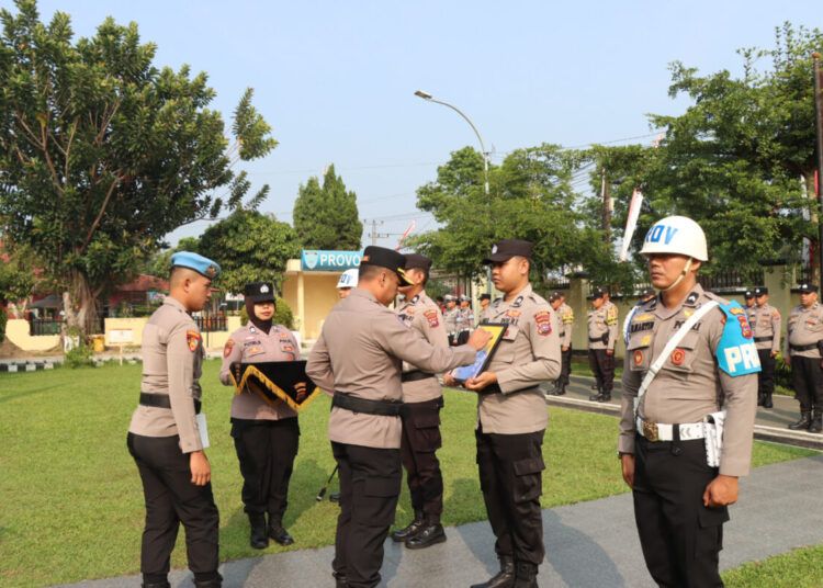 Kepala Polres Payakumbuh, AKBP Irwan Andeta, menyilang foto dua polisi yang dipecat dalam upacara PTDH di lapangan upacara polres setempat pada Rabu (12/8/2026). Foto: Polres Payakumbuh