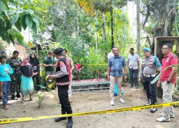 Polisi memasang garis polisi di tempat penemuan janin di Jorong Koto Kaciak, Nagari VII Koto Talago, Kecamatan Guguak, Lima Puluh Kota, Sumatera Barat (Sumbar), menemukan janin berlumuran darah di belakang rumah seorang warga pada Kamis (13/8/2026). Foto: Polsek Guguak