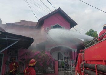 Petugas damkar menyemprotkan air bertekanan tinggi ke rumah yang terbakar di Jalan Citandui Nomor 7A, RT 001 RW 001, Kelurahan Alai Parak Kopi, Kecamatan Padang Utara, Kota Padang, pada Minggu (16/8/2026) sore. Foto: Damkar Padang