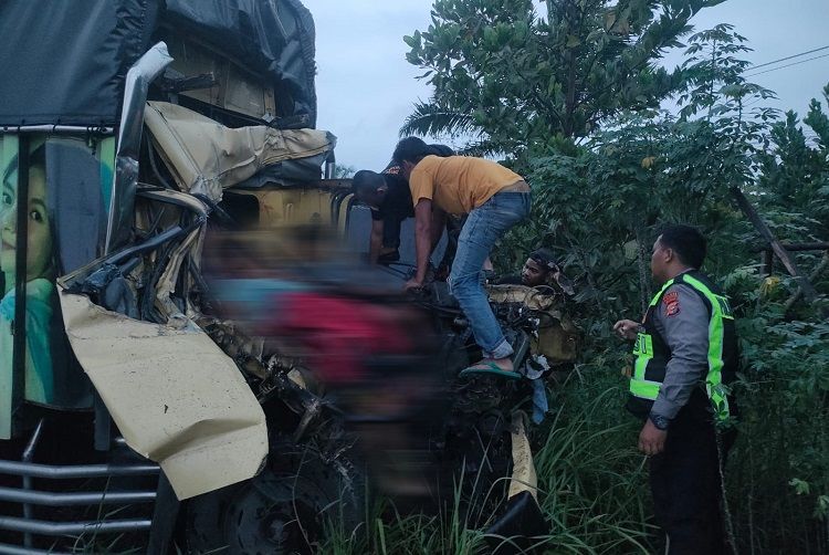 Seorang warga memeriksa kondisi pengendara dan tiga penumpang truk yang kecelakaan di di Jalan Umum Pekanbaru—Bangkinang, tepatnya di Desa Rimbo Panjang, Kecamatan Tambang, Kabupaten Kampar, Riau, pada Sabtu (19/9/2026) dini hari. Foto: Ditlantas Polda Riau