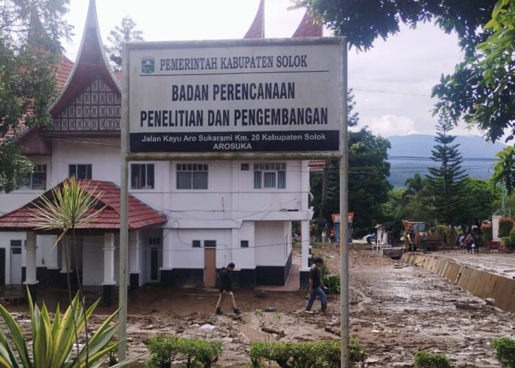 Gedung Bapelitbang Pemkab Solok terlihat masih berdiri utuh setelah kawasan Kompleks Perkantoran Pemkab Solok diterjang galodo, Selasa (22/9/2026). Material lumpur, batu, dan kayu terlihat menumpuk di sekitar gedung.