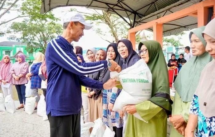 Wakil Bupati Solok Selatan H. Yulian Efi menyerahkan bantuan pangan beras kepada penerima manfaat di RTH Muara Labuh, Kecamatan Sungai Pagu, Minggu (27/9/2026).