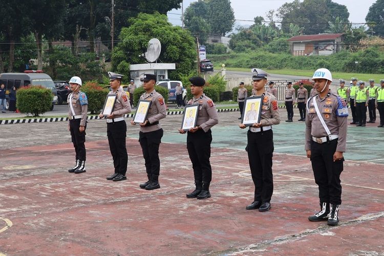 Empat polisi memegang foto empat foto polisi yang dipecat dalam Upacara PTDH Markas Polres Solok Selatan pada Senin (21/9/2026). Foto: Polres Solok Selatan