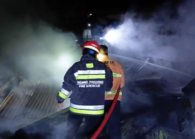 Petugas pemadam kebakaran melakukan penanganan rumah yang terbakar akibat tersambar petir di Jorong Ladang Laweh, Nagari Batipuh Baruah, Kecamatan Batipuh, Tanah Datar, Kamis (1/10/2026) malam.