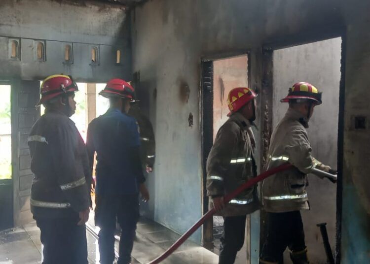 Petugas melakukan pemadaman rumah yang terbakar di Jorong Simpang Empat Kabindu, Nagari Labuh Gunung, Kecamatan Lareh Sago Halaban, Kabupaten Lima Puluh Kota, Jumat (9/10/2026).